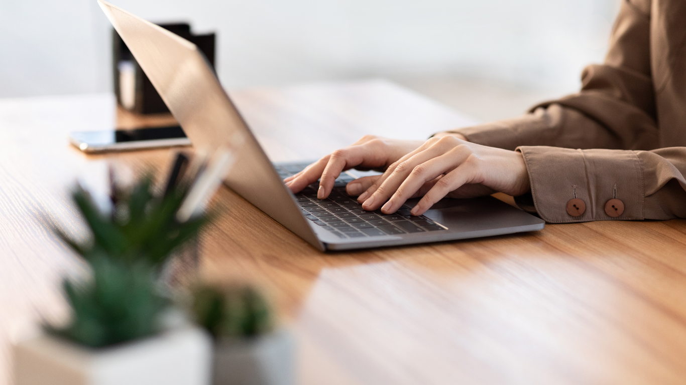 Frau tippt am Laptop – Kontakt zu Sandra Radic